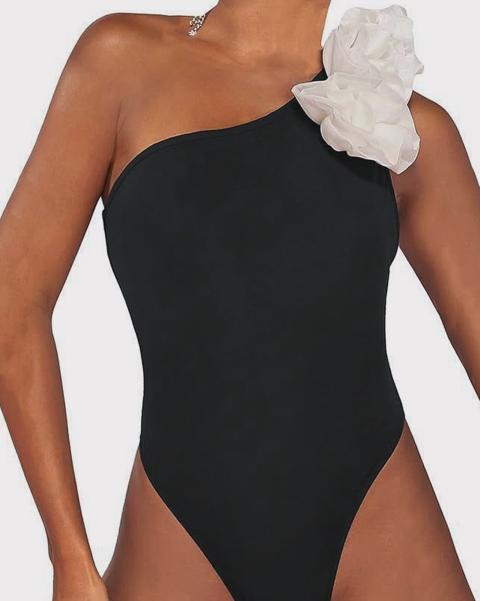 Zwart asymmetrisch badpak met witte bloem - Bakkermode.nl