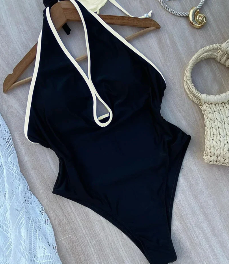 Zwart halter badpak met witte rand en bloemdetail - Bakkermode.nl