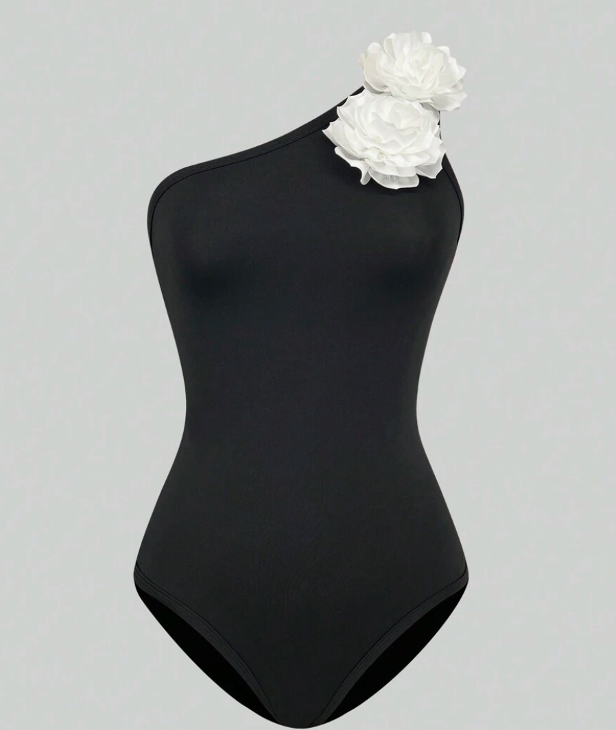 Zwart asymmetrisch badpak met witte bloem - Bakkermode.nl