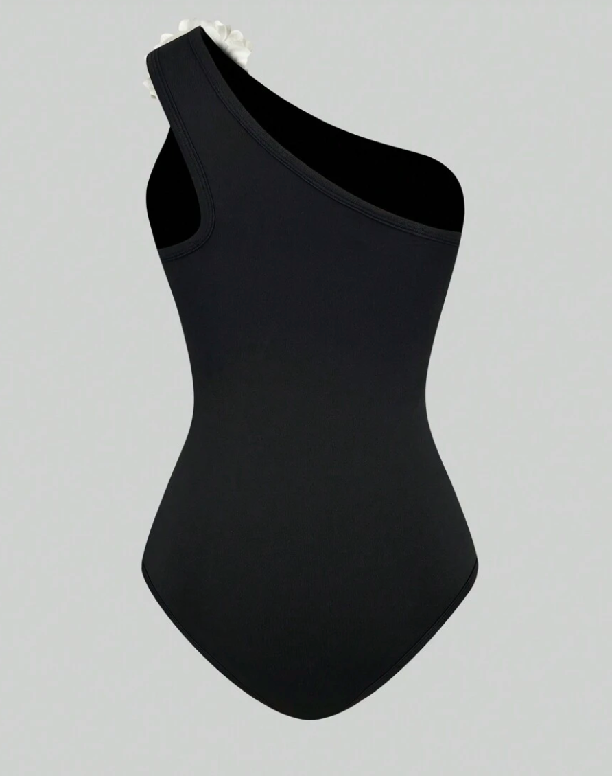 Zwart asymmetrisch badpak met witte bloem - Bakkermode.nl