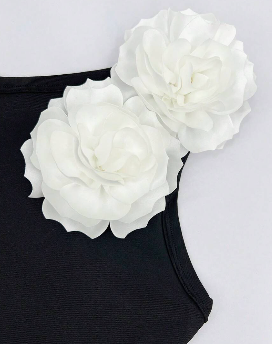 Zwart asymmetrisch badpak met witte bloem - Bakkermode.nl