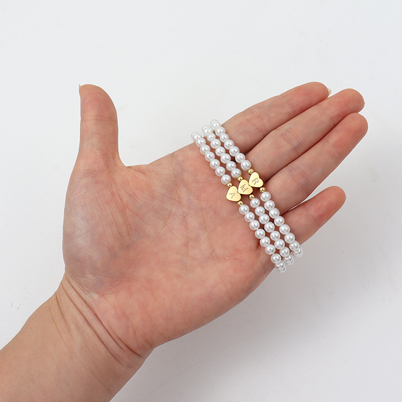Parelarmband - elegante witte damesarmband met hartjesbedel