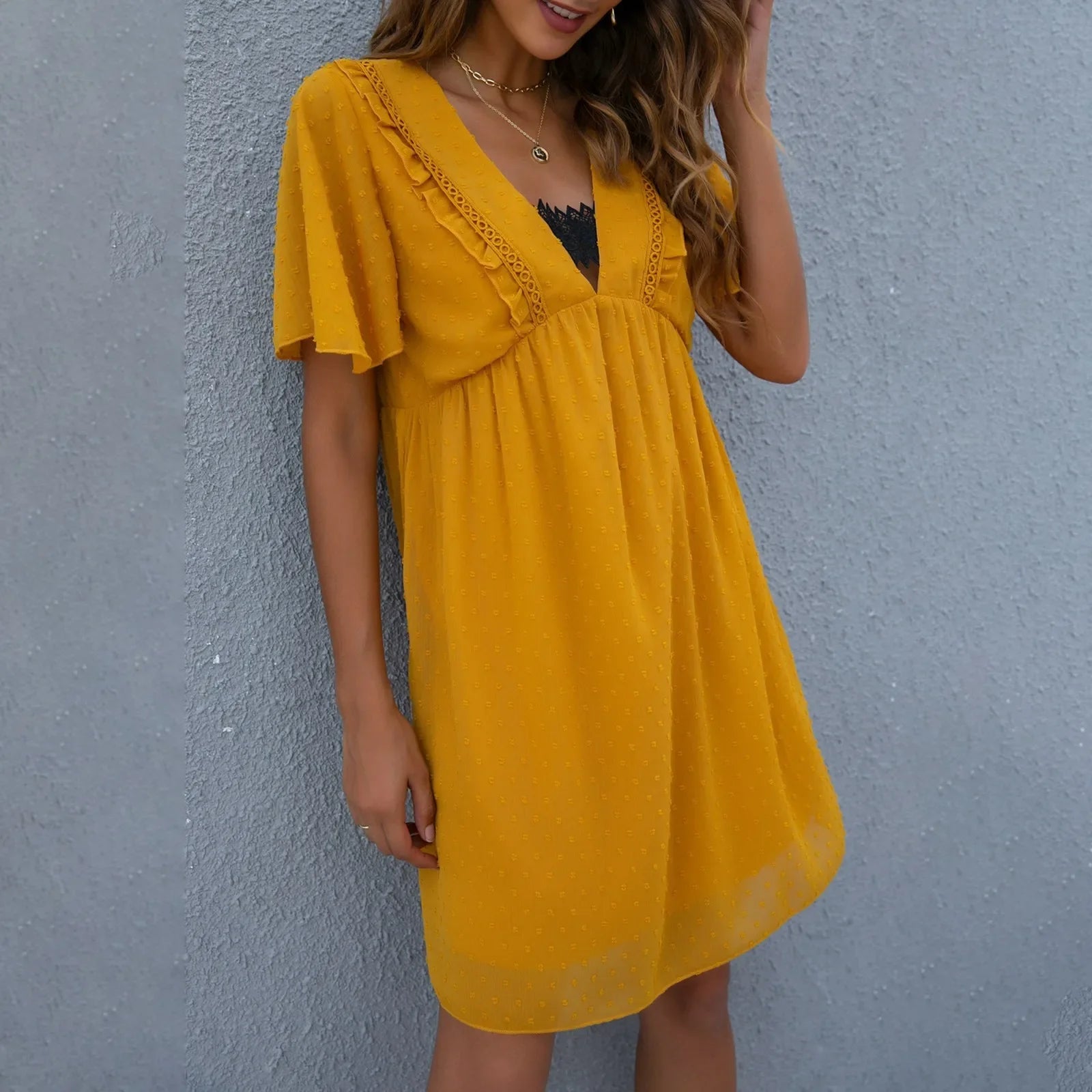 Zomerse jurk met V-hals en kantdetails - Bakkermode.nl