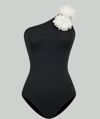 Zwart asymmetrisch badpak met witte bloem - Bakkermode.nl